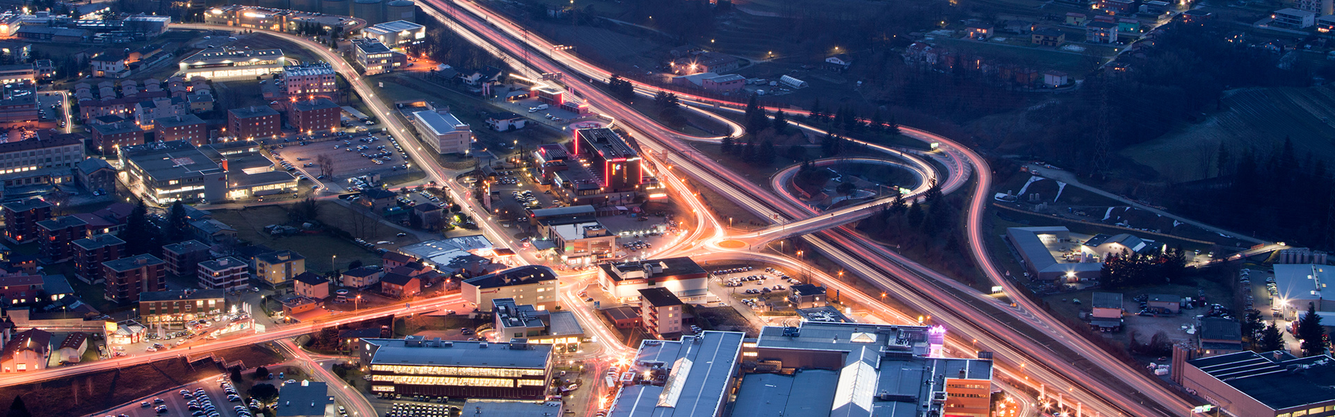 Stadtteil / Agglomeration im Halbdunkel mit erleuchteten Strassen und Gebäuden 