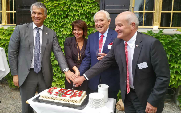 Sergio Ermotti, CEO UBS; Bundespräsidentin Doris Leuthard; Rainer E. Gut, Ehrenpräsident CS und Martin Naville, CEO AmCham Switzerland schneiden die Geburtstagstorte an.