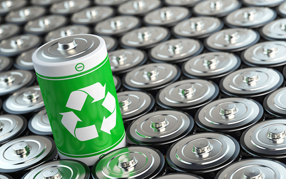 Collezione di batterie viste da sopra. Al centro una batteria di colore verde, con il simbolo recycling. 